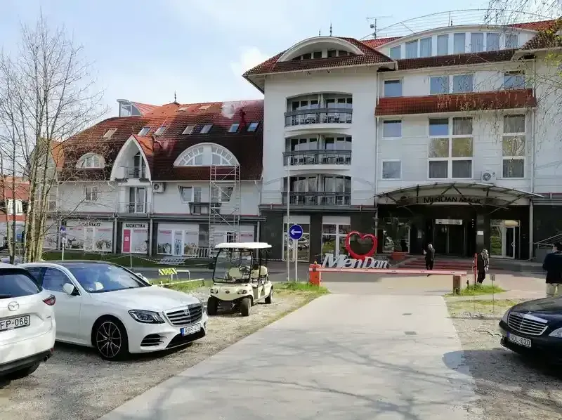 A képen a zalakarosi mendan hotel látható aminek tetején két szakember mossa a tetőt.